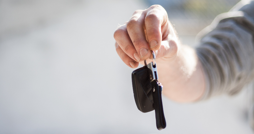 hand holding out car keys following sale to scrap yard